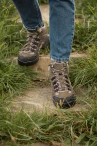 Botas de senderismo en acción sobre sendero natural con vegetación