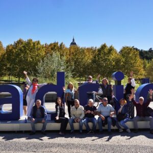 Grupo posando con entusiasmo junto a las letras gigantes de Madrid.