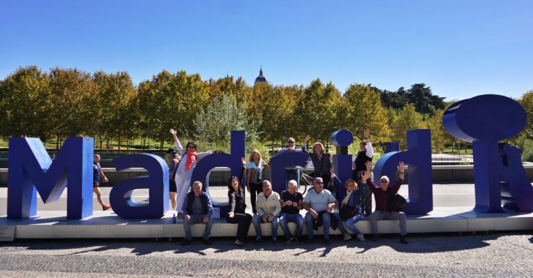 Grupo posando con entusiasmo junto a las letras gigantes de Madrid.