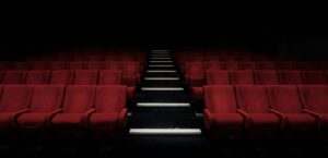 Sala de cine vacía con butacas rojas, símbolo de películas que remueven conciencias y no siempre llegan al gran público.