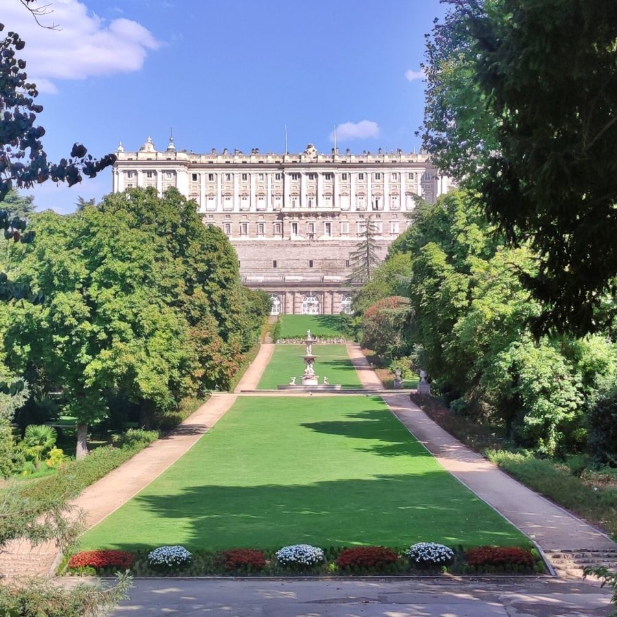 Vista del Palacio Real desde los Jardines del Campo del Moro, enmarcado por árboles.
